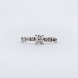 Anillo de compromiso oro blanco 14K con diamante cushion central 54 y diamantes laterales 10 pts